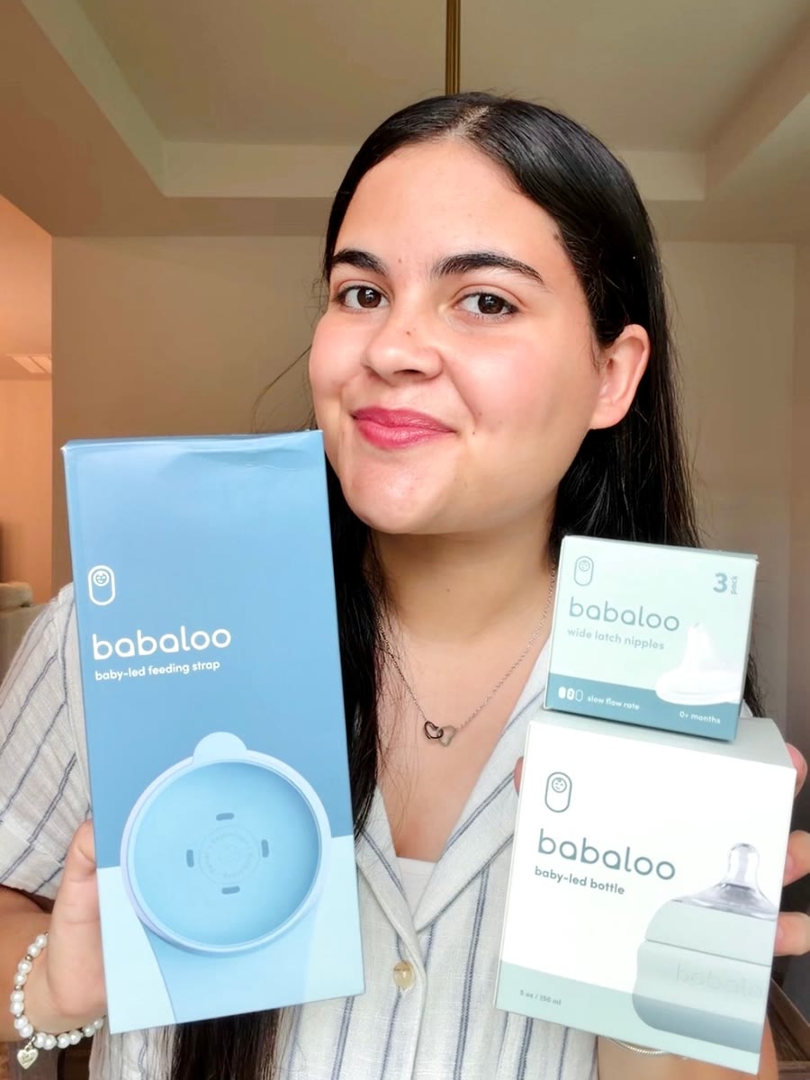 Kathlyn smiling and holding Babaloo baby-led feeding strap, bottle and nipple boxes