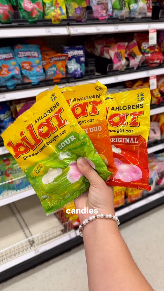 Three bags of Ahlgrens Bilar candy held up in a Target aisle